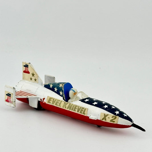 Image of 4.5 inch long rocket with red base, white top, blue cockpit with white stars. Driver in white, stickers all attached