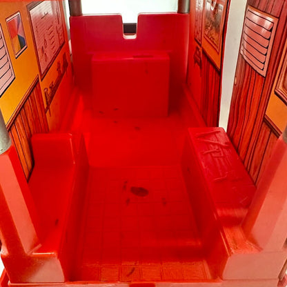 Red plastic play structure with steps inside a building