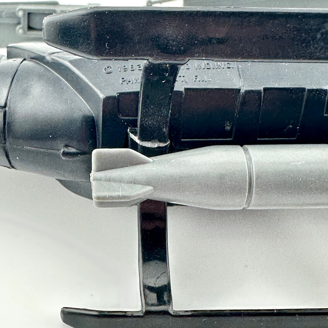 Close-up of a bottom of toy helicopter with repaired section against white background