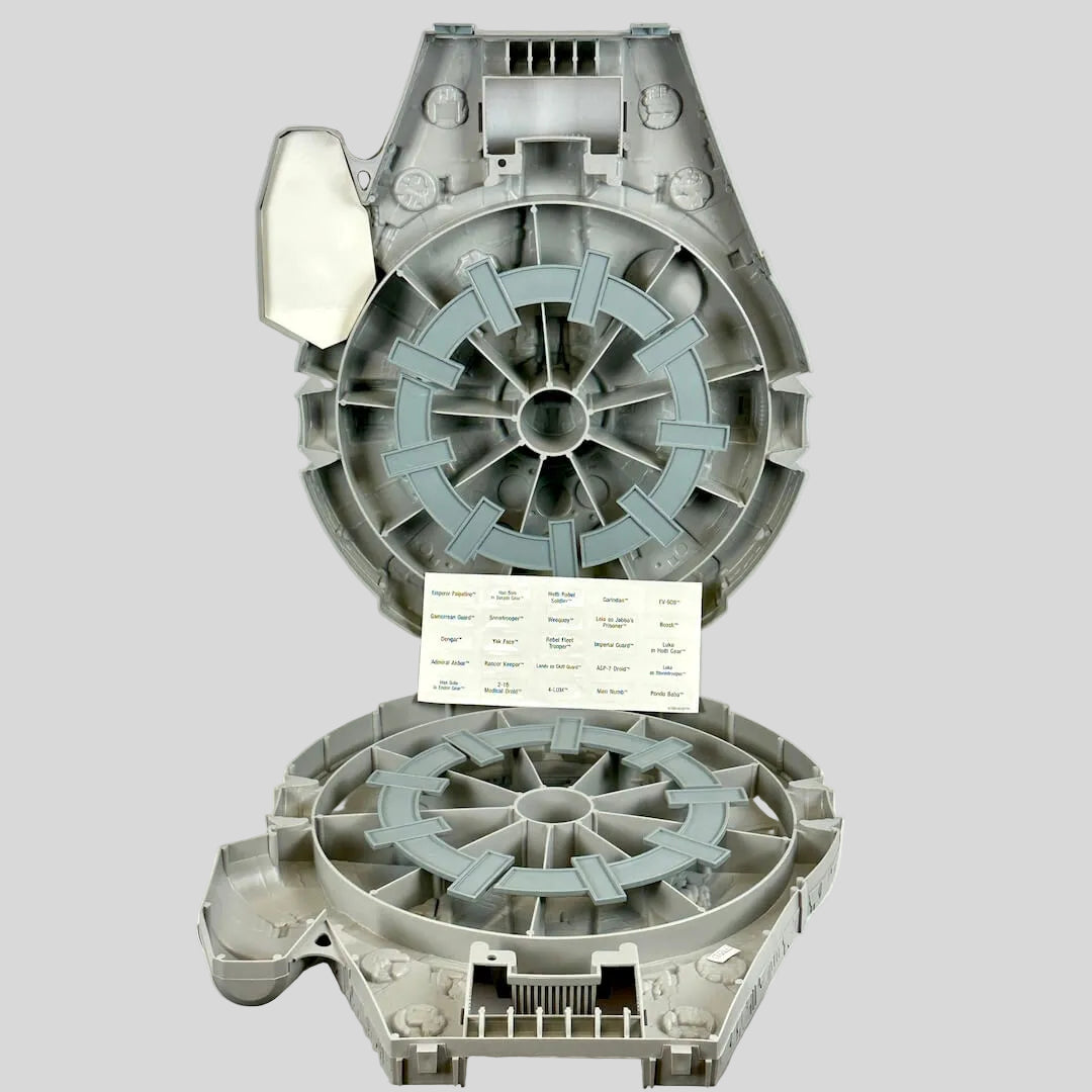 Open carrying case shaped like Millennium Falcon with sticker sheet on light background. 