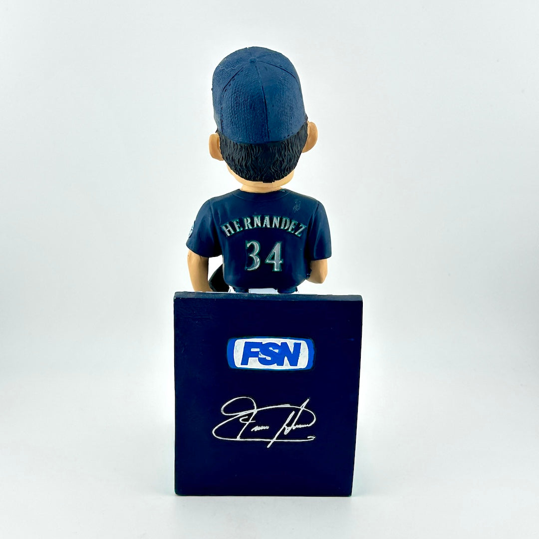 Bobblehead figure of a sports player with a cap and jersey, standing on a blue box with 'FSN' branding.