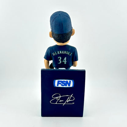 Bobblehead figure of a sports player with a cap and jersey, standing on a blue box with 'FSN' branding.