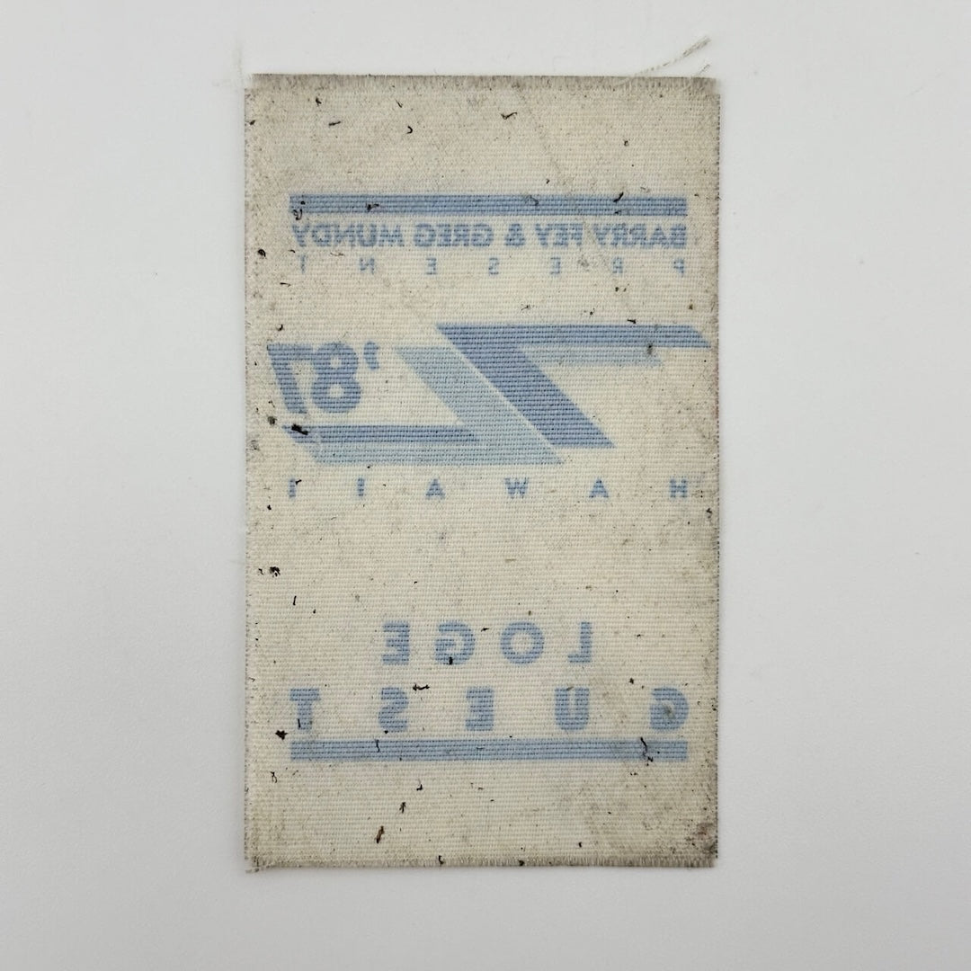 Backside of white fabric event pass with ghost image of other side visible. 