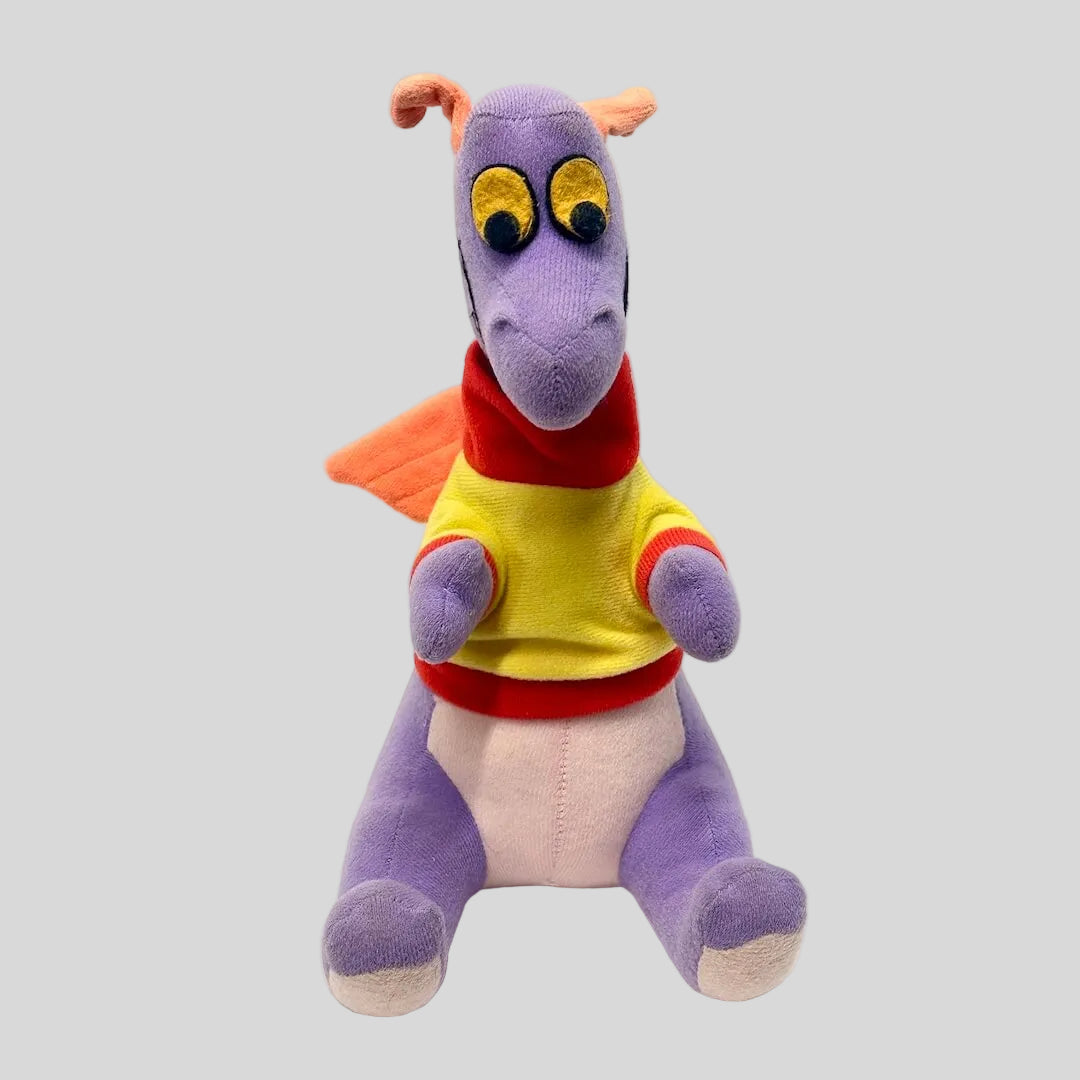 Colorful plush toy with a purple body and yellow shirt on a white background