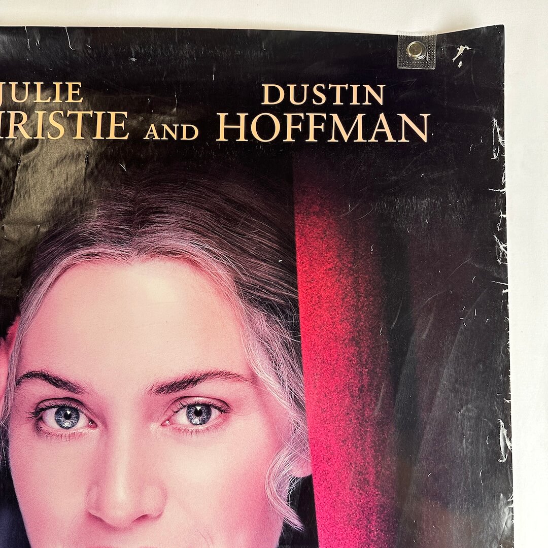 Vintage movie poster with a woman's face and actor names on a black background. Wear to edges.