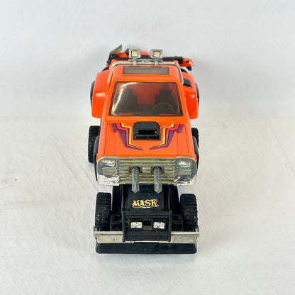 An orange toy truck with purple graphic decals, a black front bumper, and a silver grille.