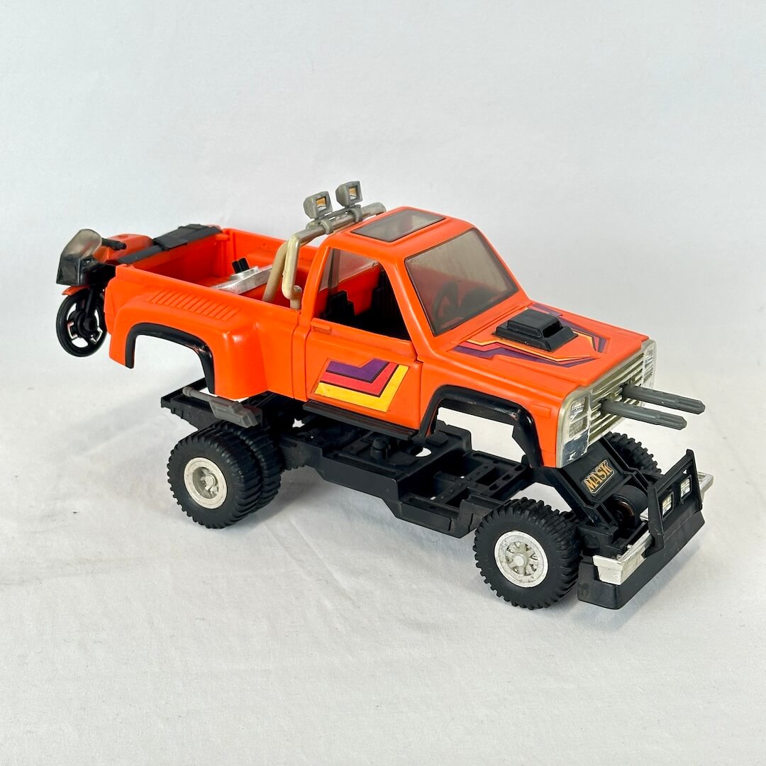 An orange and black toy pickup truck with purple and yellow graphic accents.