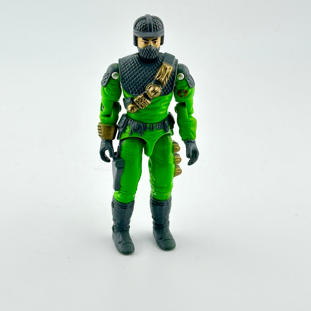 Toy figure in green and black outfit on a white background