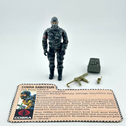 A GI Joe action figure with a black and gray patterned body, standing next to accessories, with a printed Cobra card.