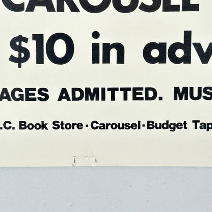 Bottom center of poster with pin holes. 