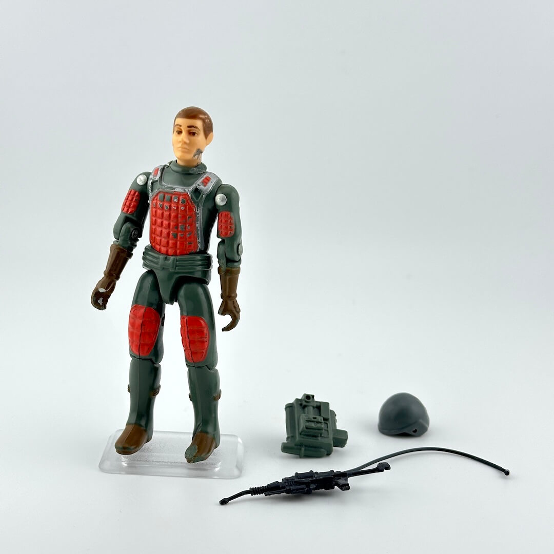 GI Joe action figure with accessories on white background. 