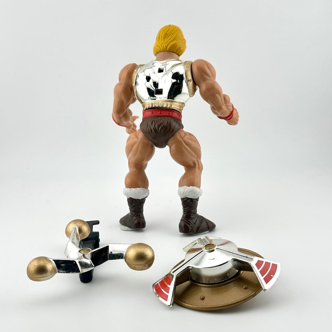Muscular action figure with gold hair and a silver chest piece on a white background