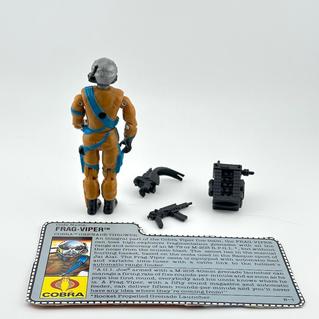 Toy figure with accessories and character card against white background.