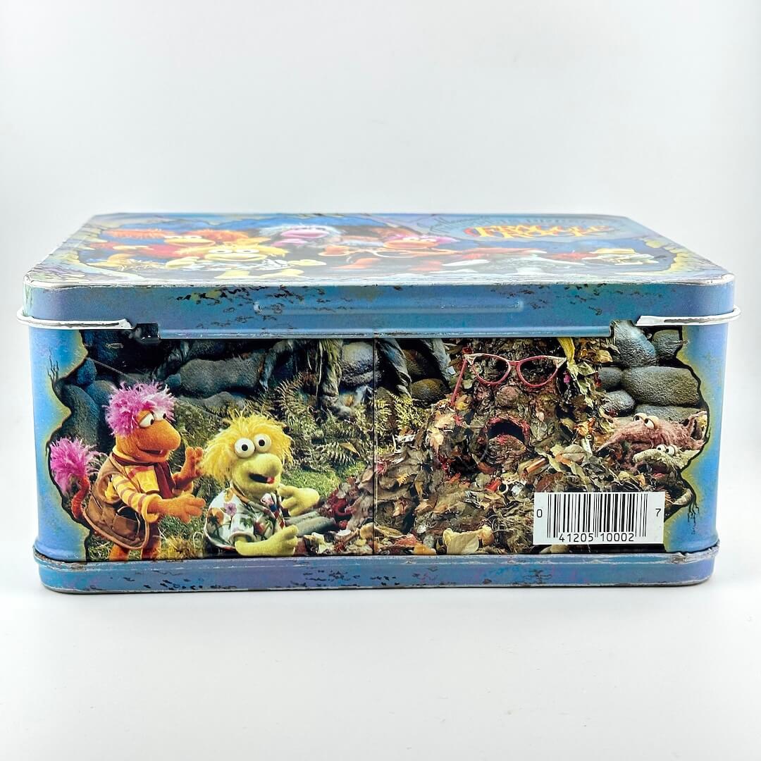View of bottom of vintage metal lunchbox with barcode and image of characters from Fraggle Rock. 