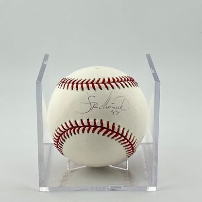 Autographed baseball in plastic cube with sticker label along bottom. Half of cube removed to show clear signature.
