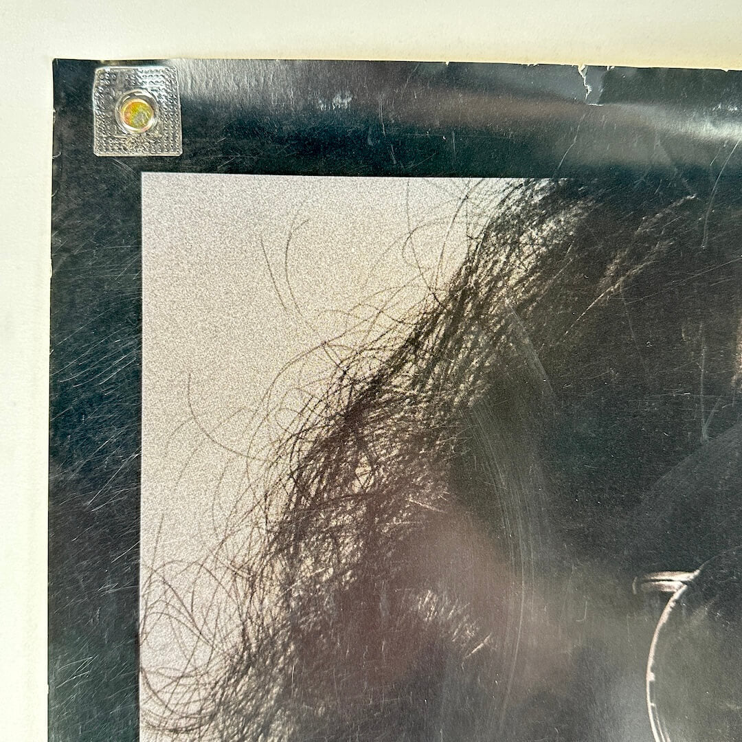 Upper left corner of poster with wear and scratches