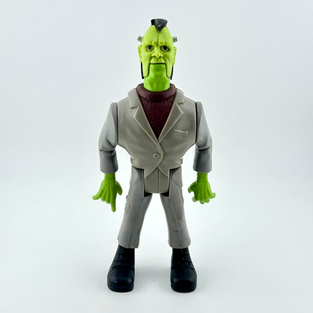 Toy figure of a character with green skin, gray suit, and black shoes on a white background