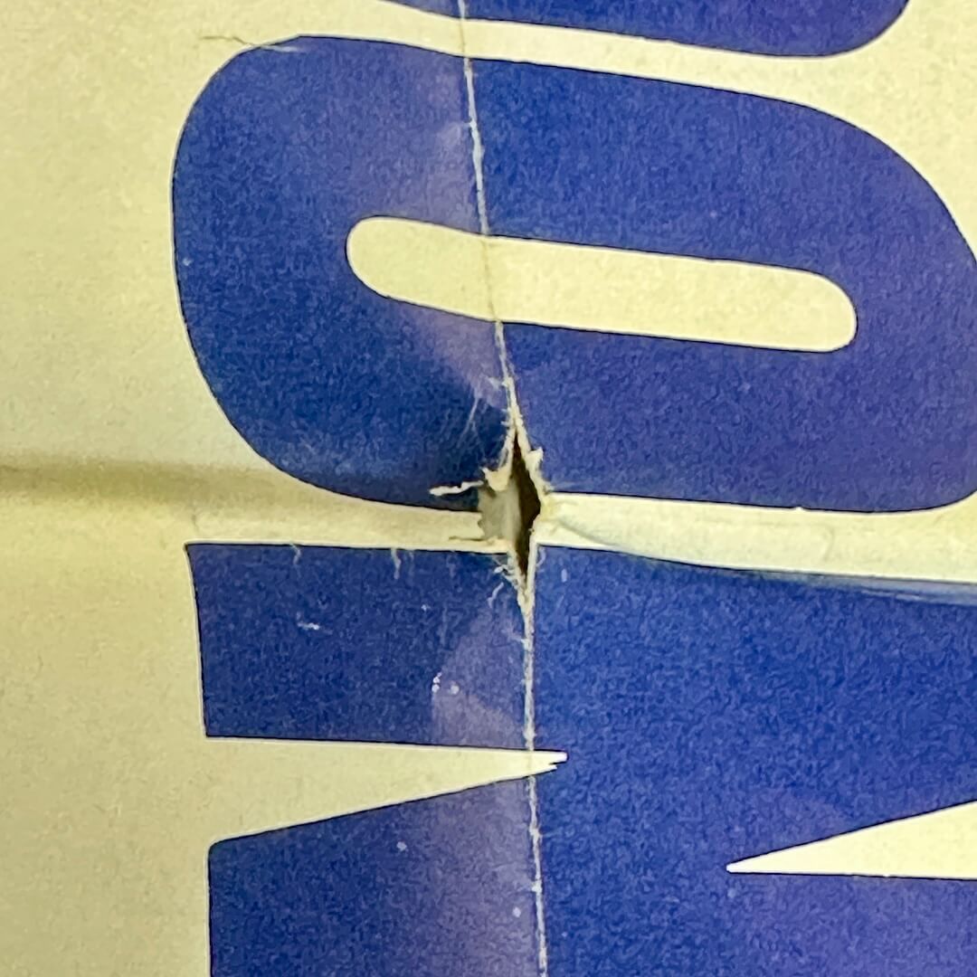 Close up of hole in poster