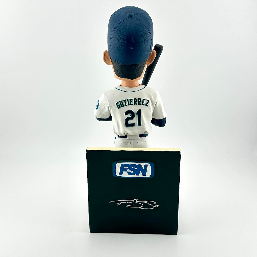 Baseball bobblehead figure with a bat, wearing a uniform and cap, on a stand with FSN logo.