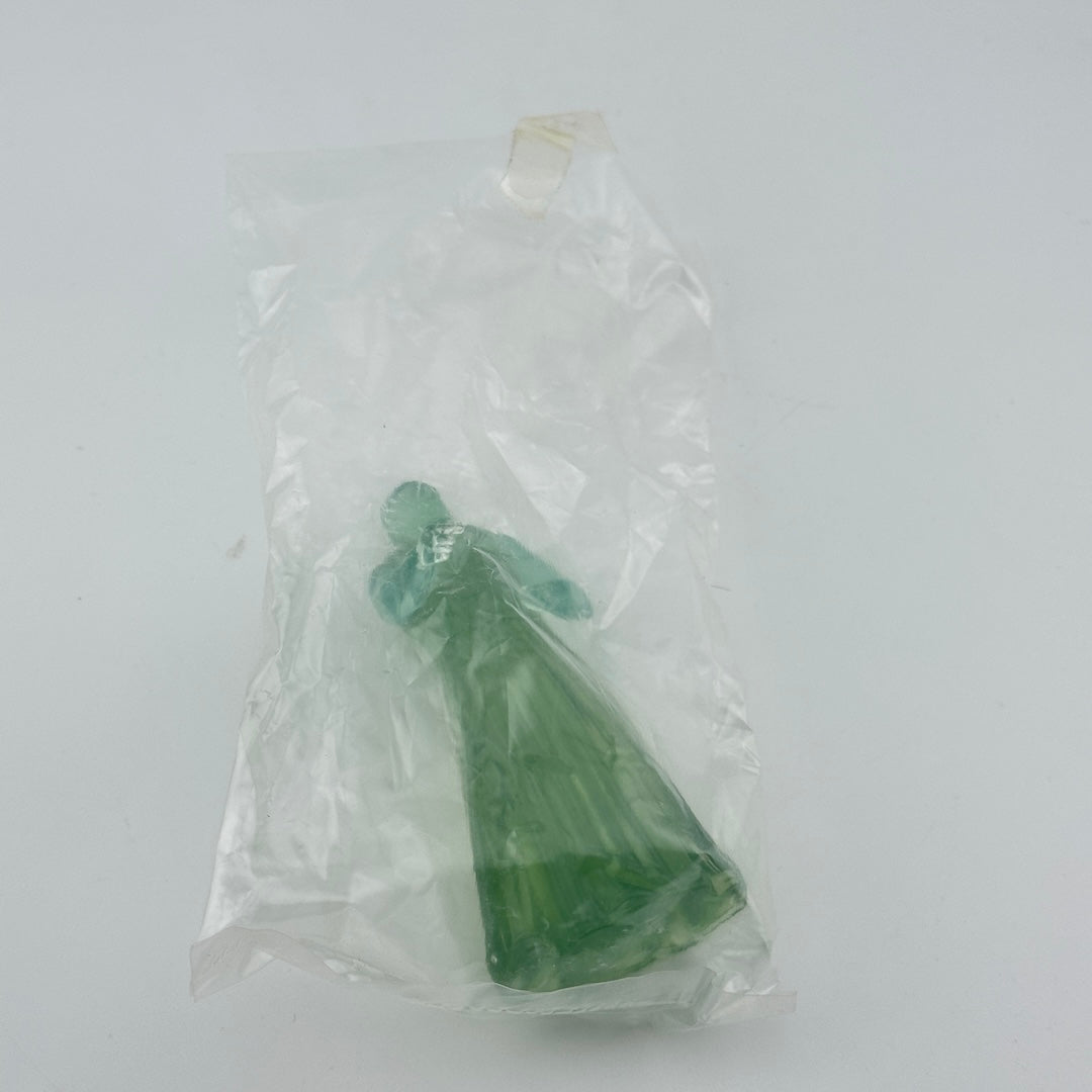 Green crystal figure in a clear plastic bag on a white background