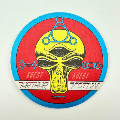 Circular fabric pass with red background and alien face as central image. 
