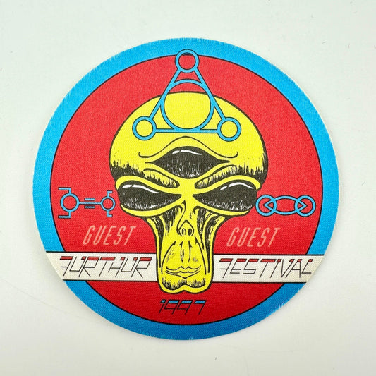 Circular fabric pass with red background and alien face as central image. 