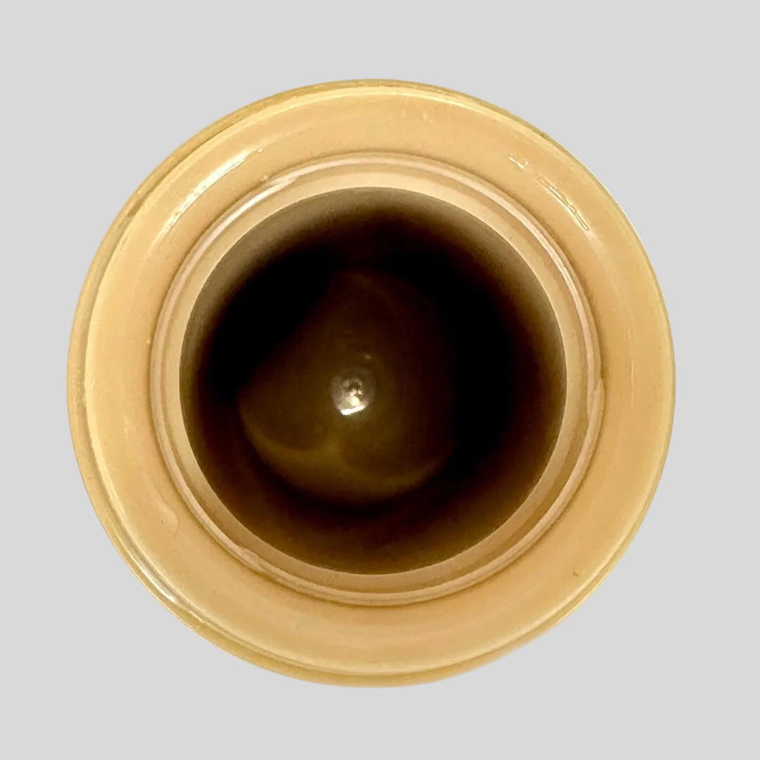 Close-up of a brown ceramic jar with a beige rim on a white background