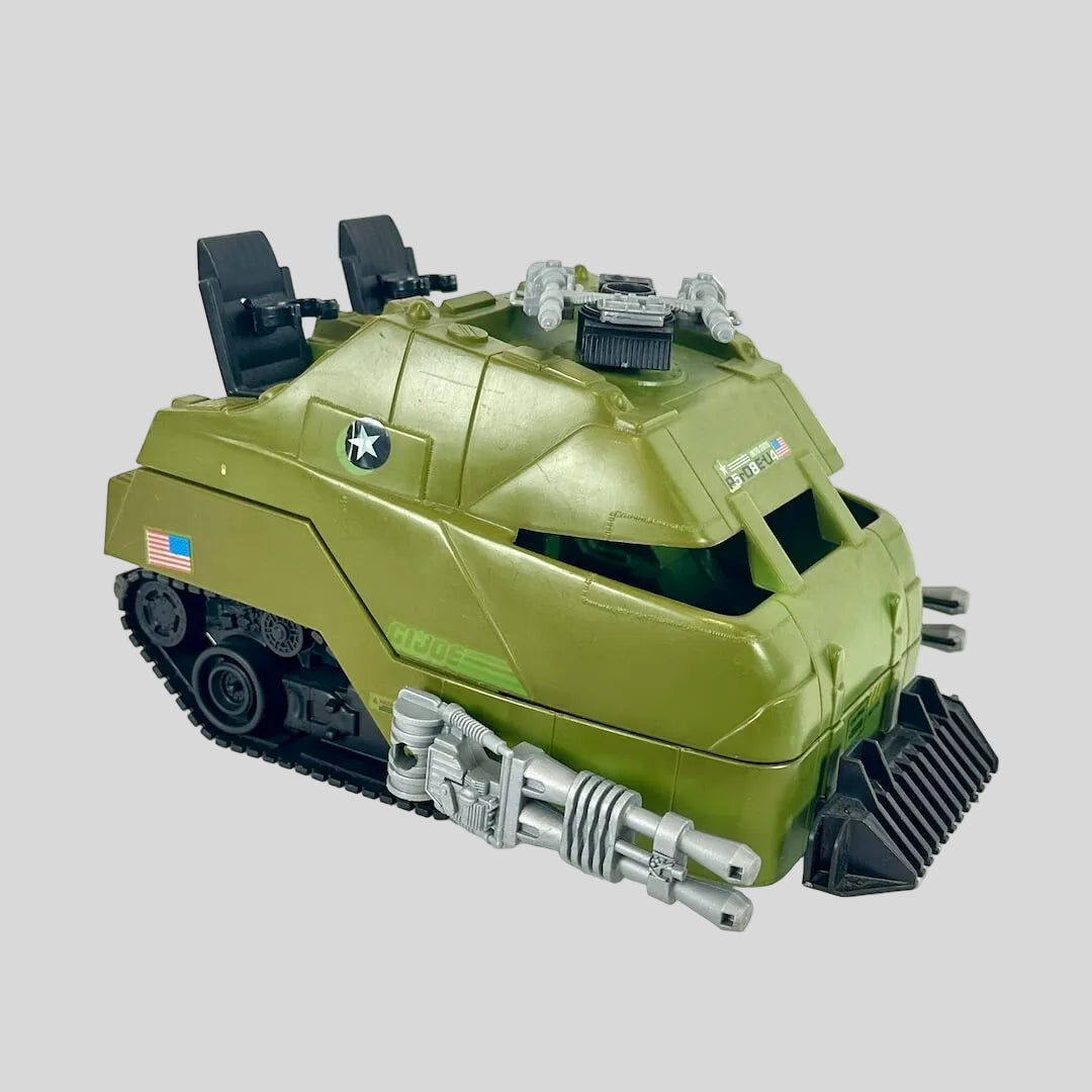 Green toy tank with gray accents on gray background.
