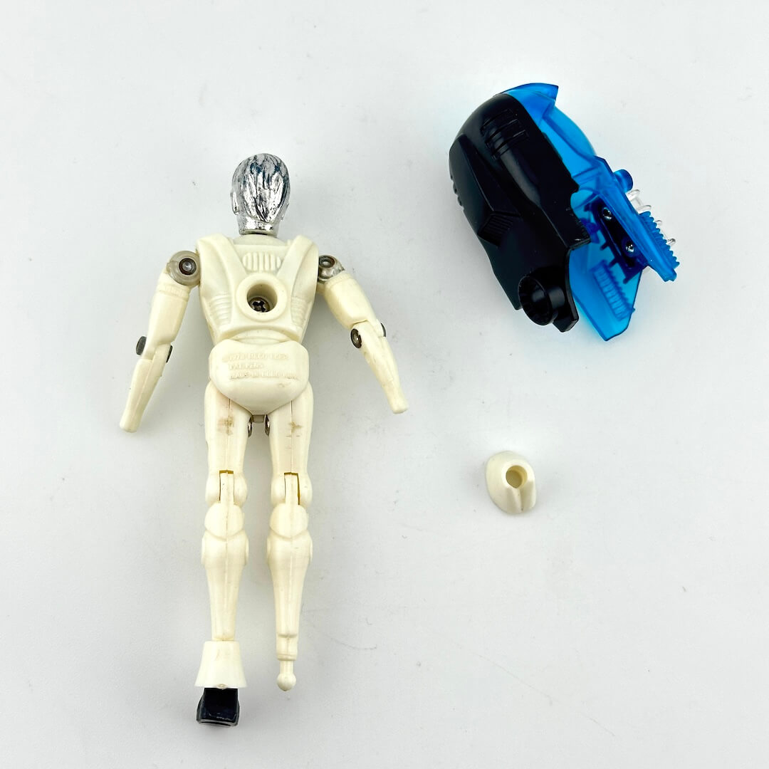 White and silver humanoid action figure with accessories laying on white background. 