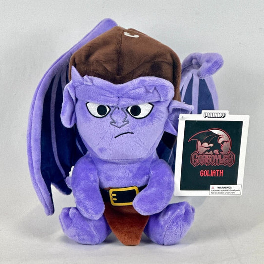 Purple cartoon character plush toy with a brown hat and pants, standing next to a card with 'Gargoyles' logo.