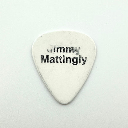 A white guitar pick printed with the black text 'Jimmy Mattingly' on a light gray background.