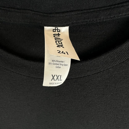 Close-up of a black knit garment showing two fabric tags at the collar, the bottom tag shows size information.