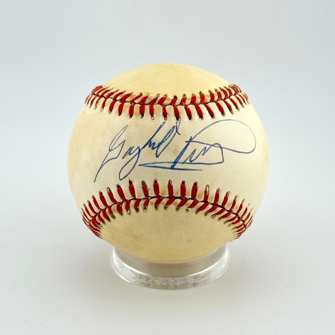 Baseball with autograph on a clear stand against a light gray background
