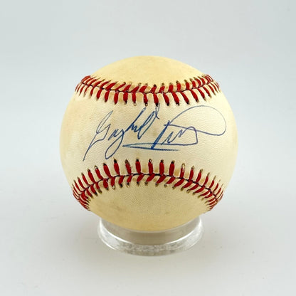 Baseball with autograph on a clear stand against a light gray background