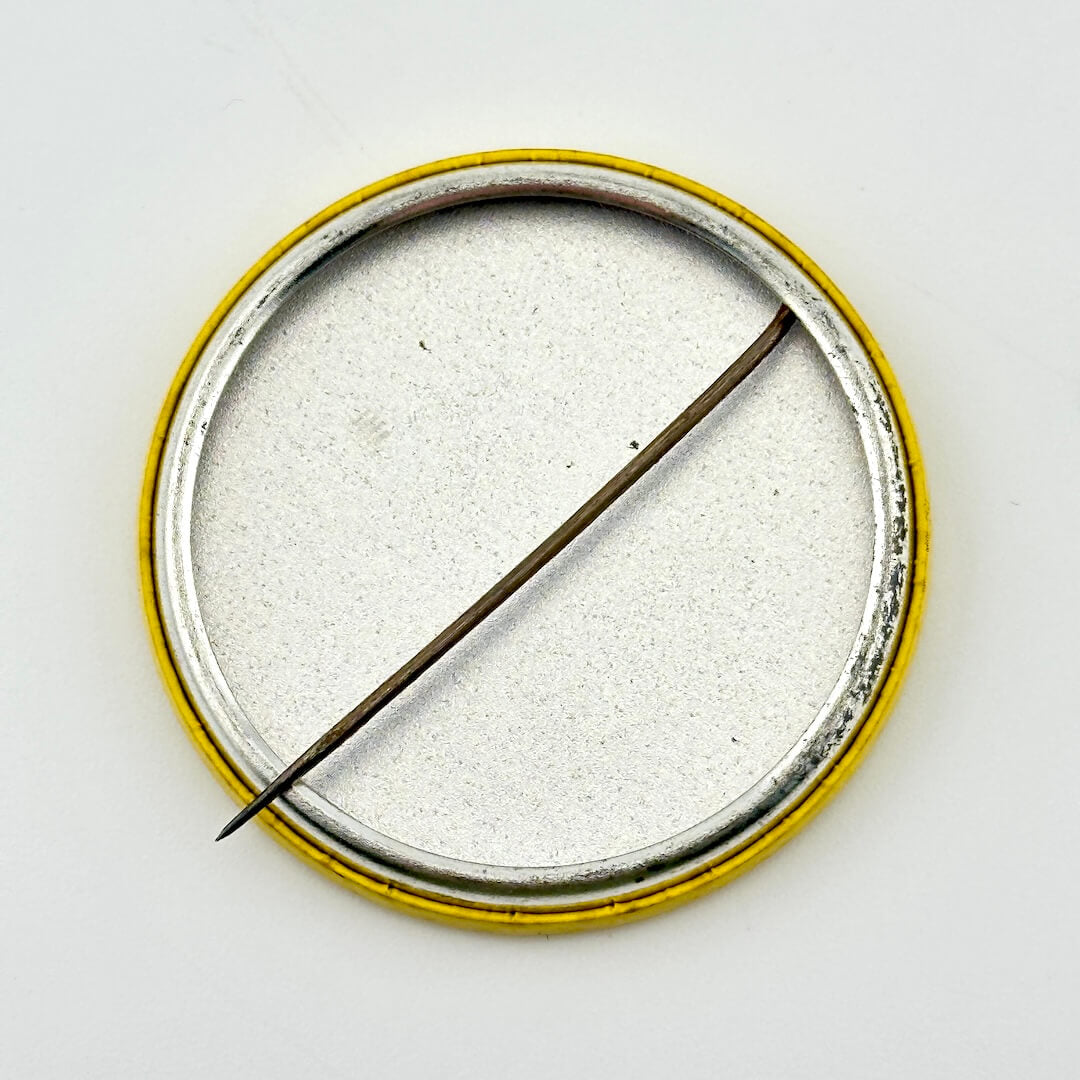 Backside of metal button against white background. 