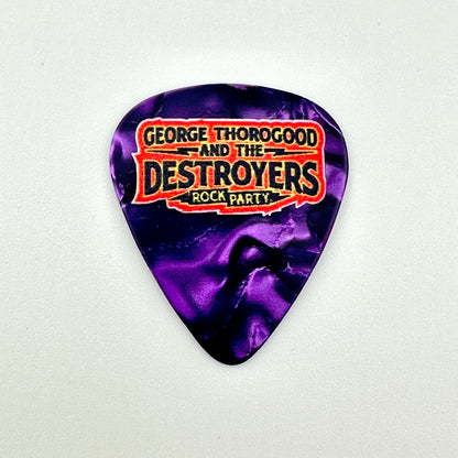 A guitar pick with a purple marbled pattern and a printed graphic reading 'George Thorogood and the Destroyers Rock Party'