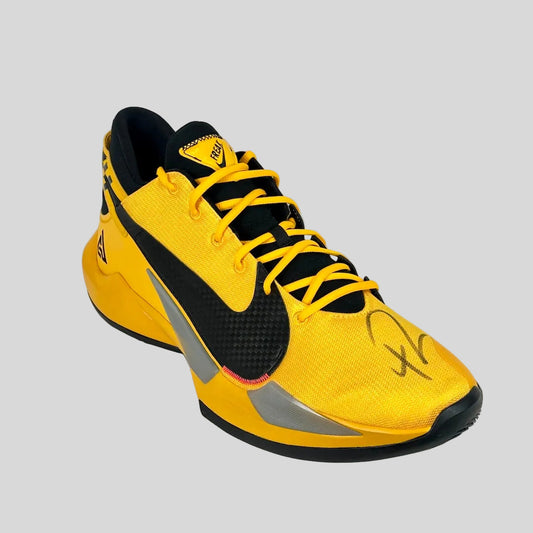 Yellow and black athletic shoe on a white background