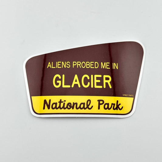 Sticker with text 'ALIENS PROBED ME IN GLACIER National Park' on a brown and yellow background