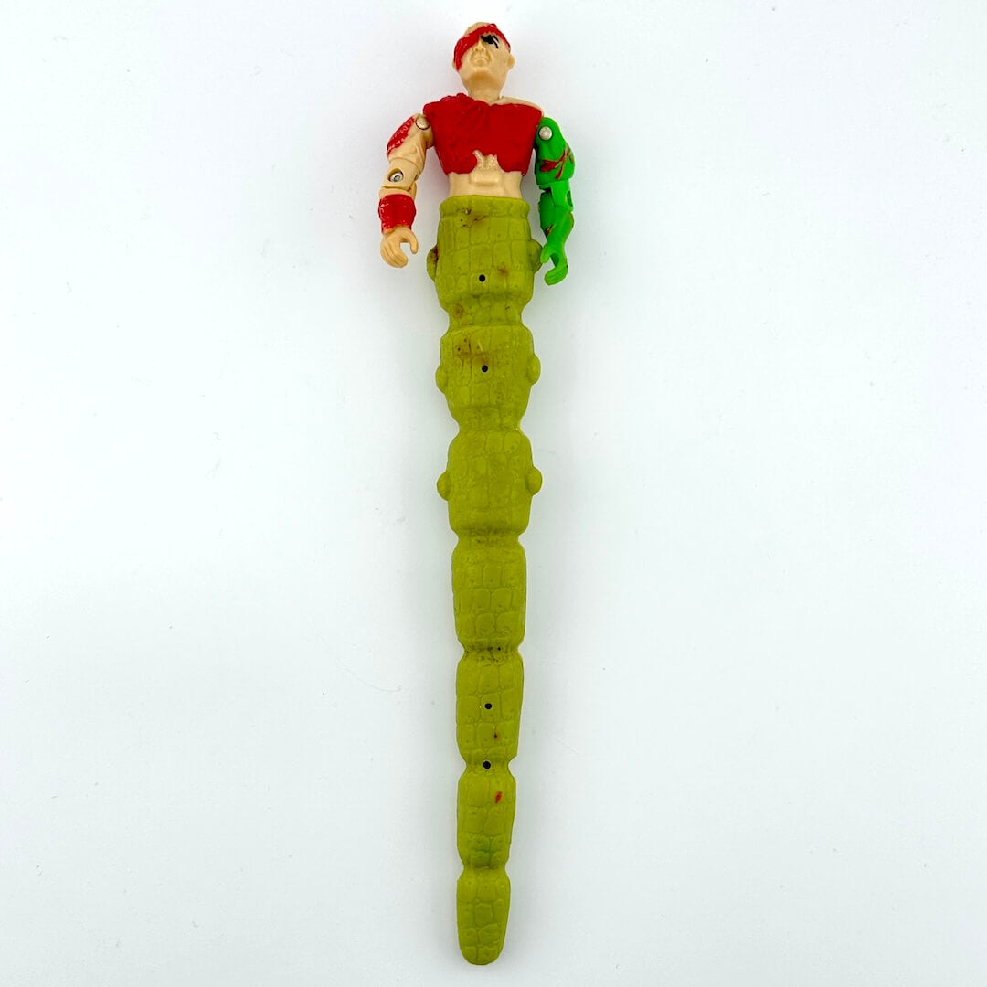 Toy figure with long green tail against white background. 