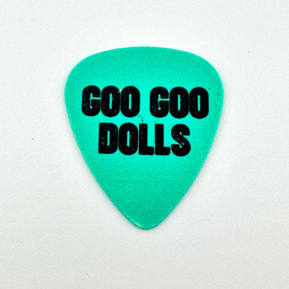 A turquoise blue guitar pick with the words 'GOO GOO DOLLS' printed in bold black letters, shown on a white background.