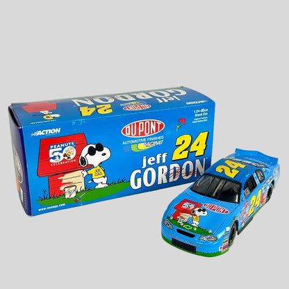 A blue diecast model race car next to its original packaging box. The box features Peanuts branding.