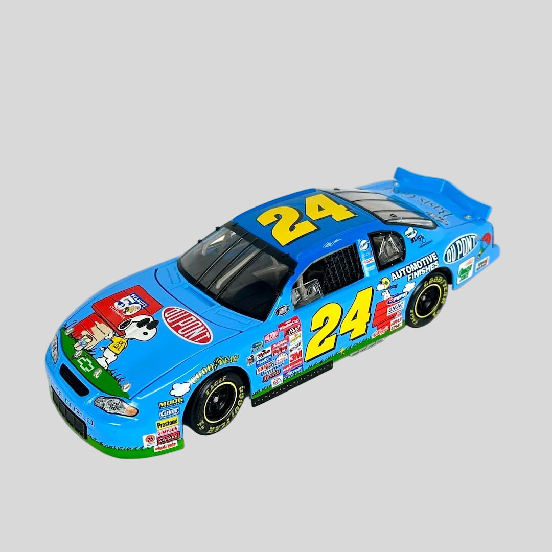 A die-cast model of a blue NASCAR race car with the number 24, featuring various sponsor decals and cartoon graphics.