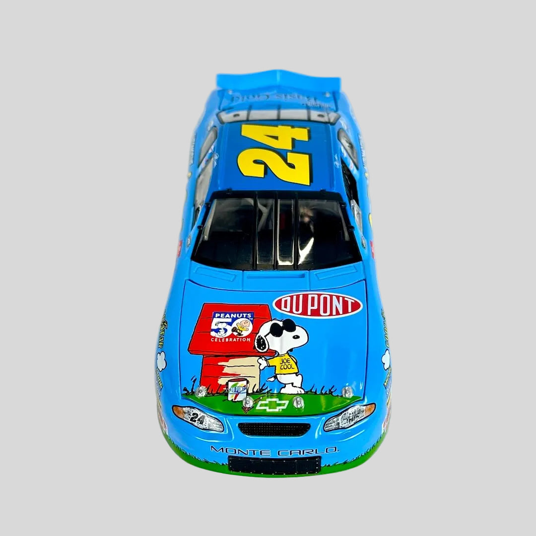 A blue toy race car featuring DuPont and Snoopy graphics, photographed on a white fabric background.