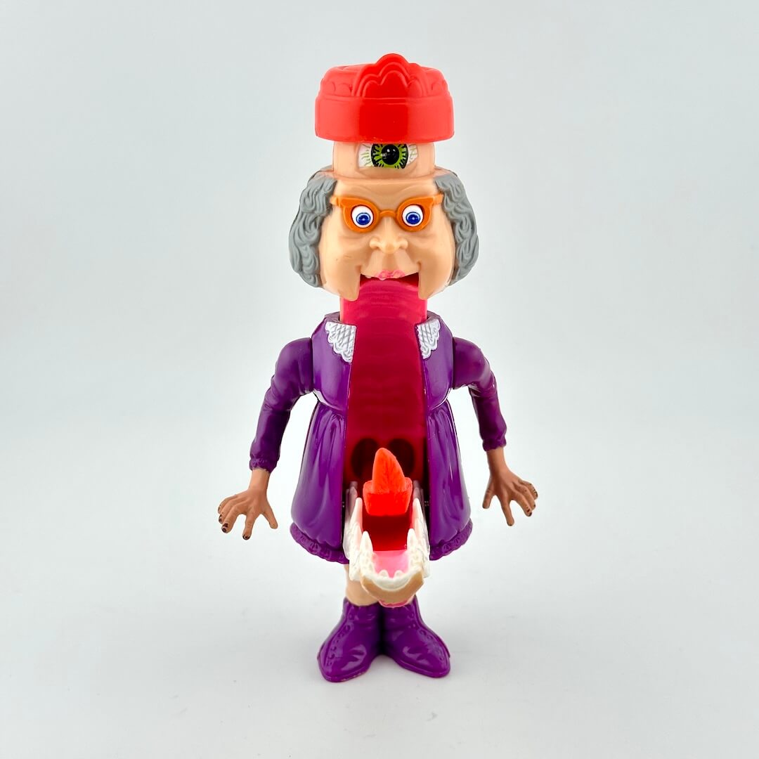 Toy figure with a red hat, purple outfit, and long tongue on a gray background
