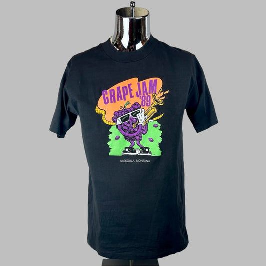 Black short sleeved, crew neck t-shirt with saxophone playing grapes as main image, event info print around it in purple. 