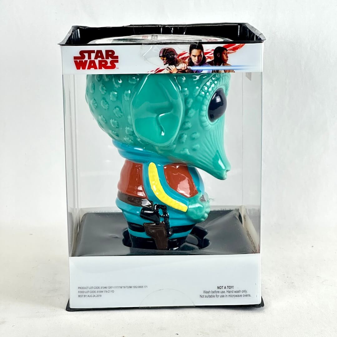 Side view of Greedo shaped turquoise mug in clear window packaging. 