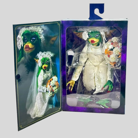 Toy figure in a wedding dress with green hair and yellow makeup, displayed in an open box.