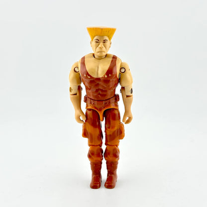 GI Joe/Street Fighter action figure in brown outfit and blonde flattop, photographed on white background. 