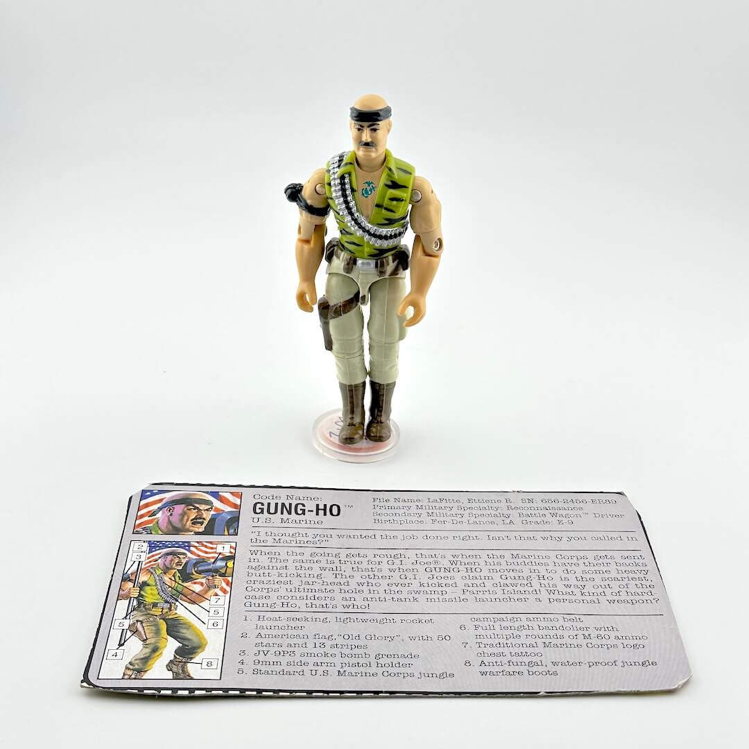 Toy figure of a character in military attire with a card below on a white background