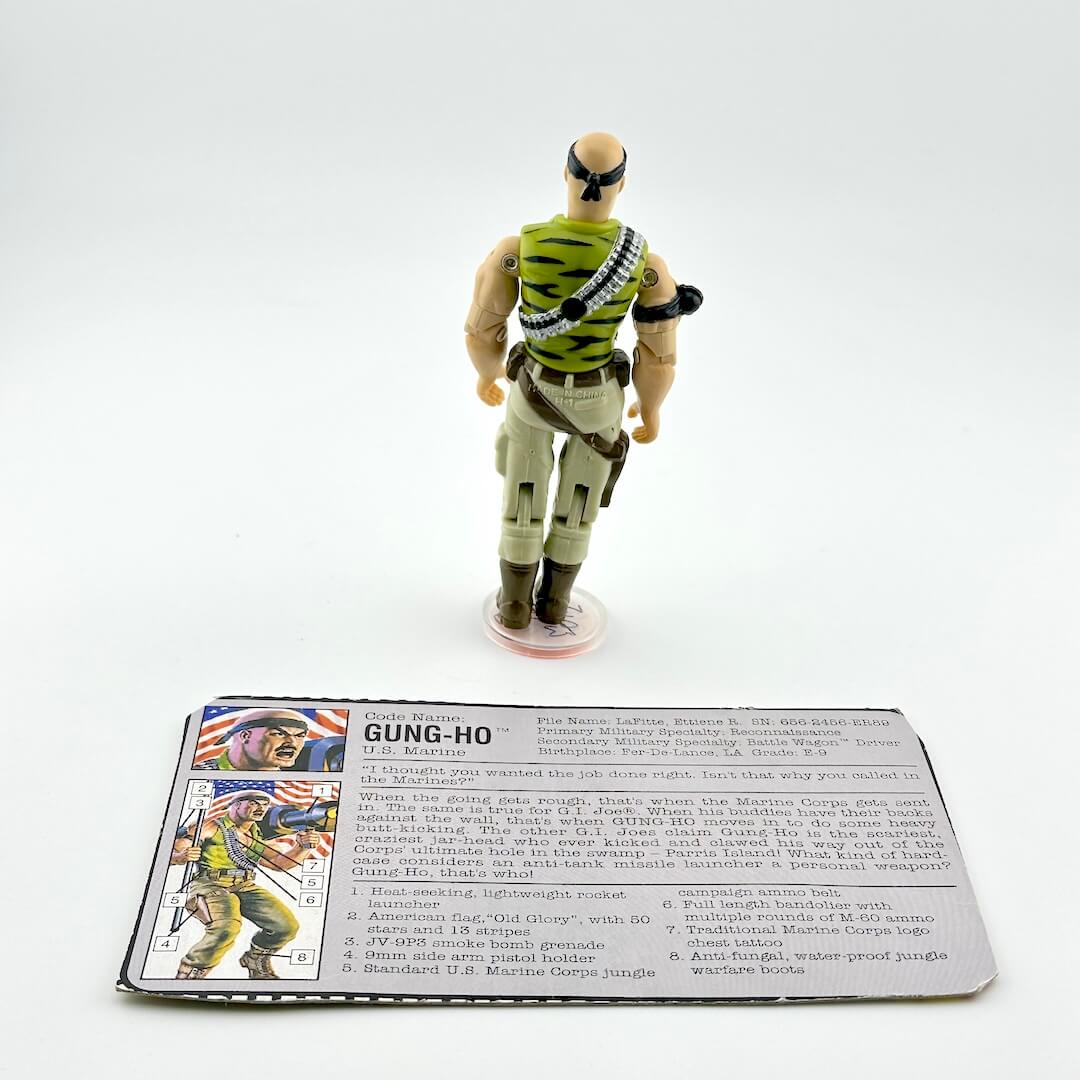 Toy figure of a character in military attire with a card below on a white background